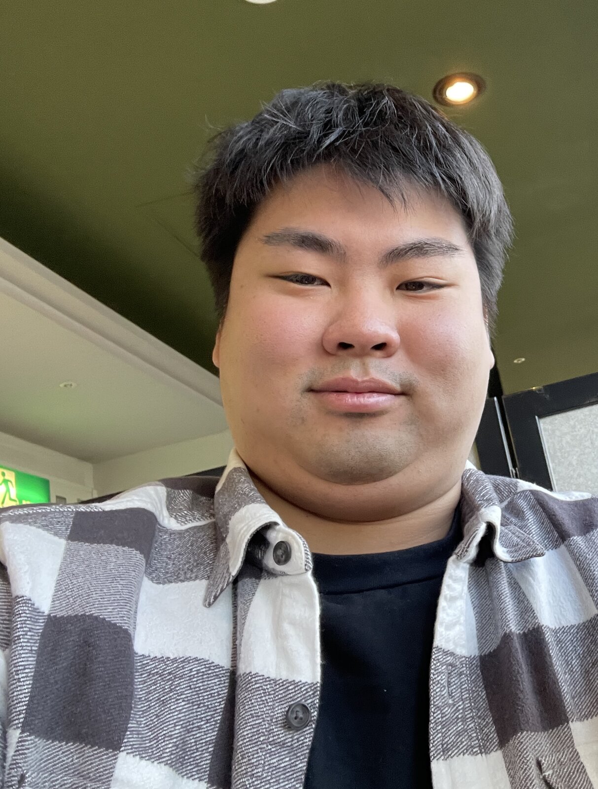 チェックのネルシャツに黒いTシャツを合わせ、ふっくらとした顔で自撮りする、人生で一番太っていた頃の迫佑樹。